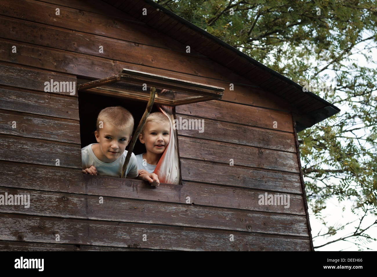 Zwei Jungs (4-7) suchen Hütte Fenster, Frankreich. Stockfoto