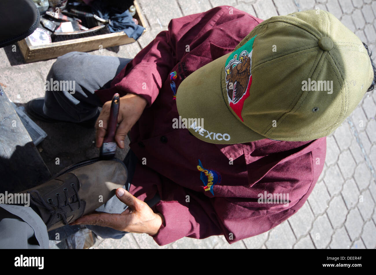 Mann mit Mexiko Baseballmütze Polieren Schuhe in Zacatlan in Mexiko Stockfoto