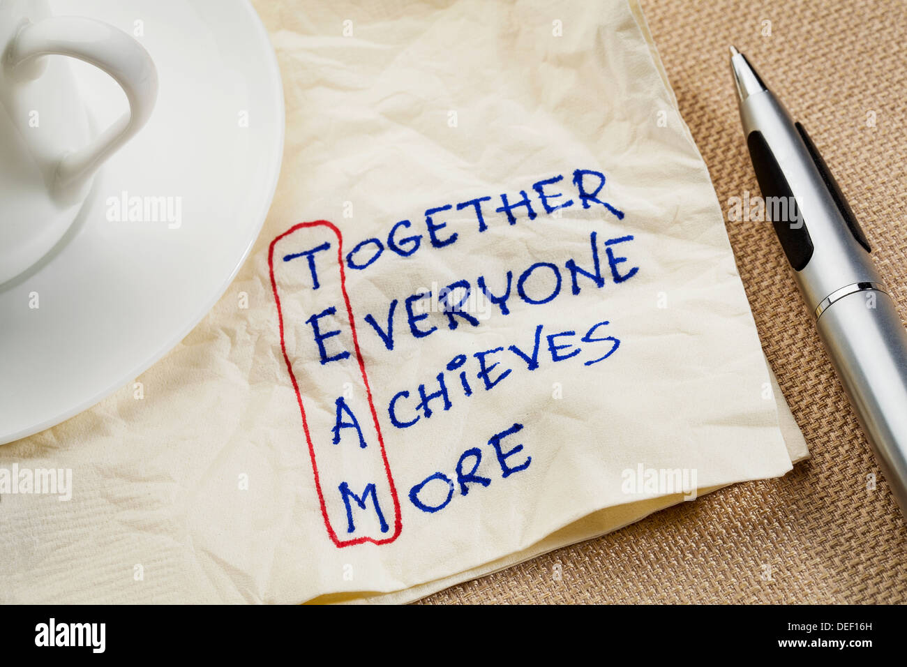 TEAM-Akronym (zusammen jeder erreicht mehr), Teamarbeit-Motivation-Konzept - eine Serviette Doodle Stockfoto