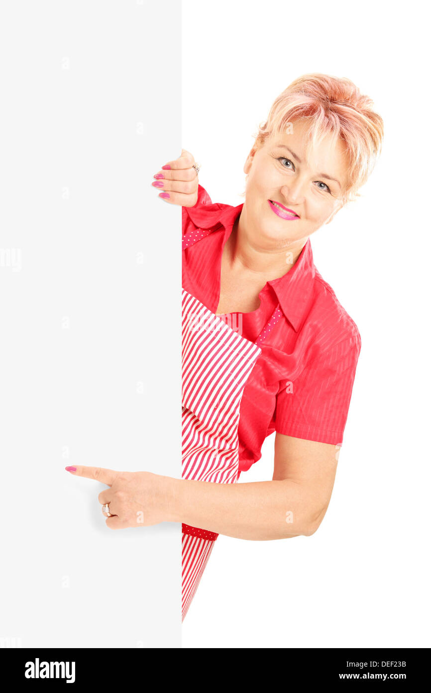 Blonde lächelnde Frau trägt eine Schürze und deutete auf eine Blindplatte Stockfoto