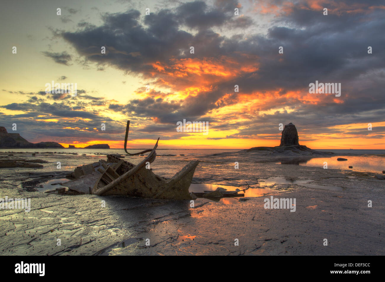 Eine feurige Himmel Einstellung über den Admiral und schwarz Nab gegen Bay südlich von Whitby an der Küste von Yorkshire. Stockfoto