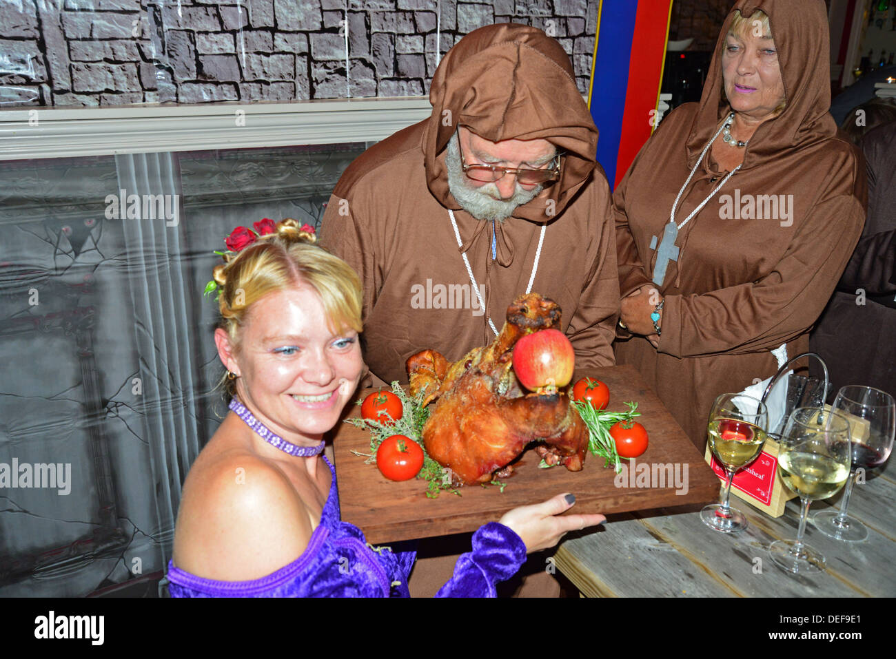 Mönch mit Spanferkel Schweinekopf nachts mittelalterliches Festmahl The Wheatsheaf Pub, Crick, Northamptonshire, England, Vereinigtes Königreich Stockfoto