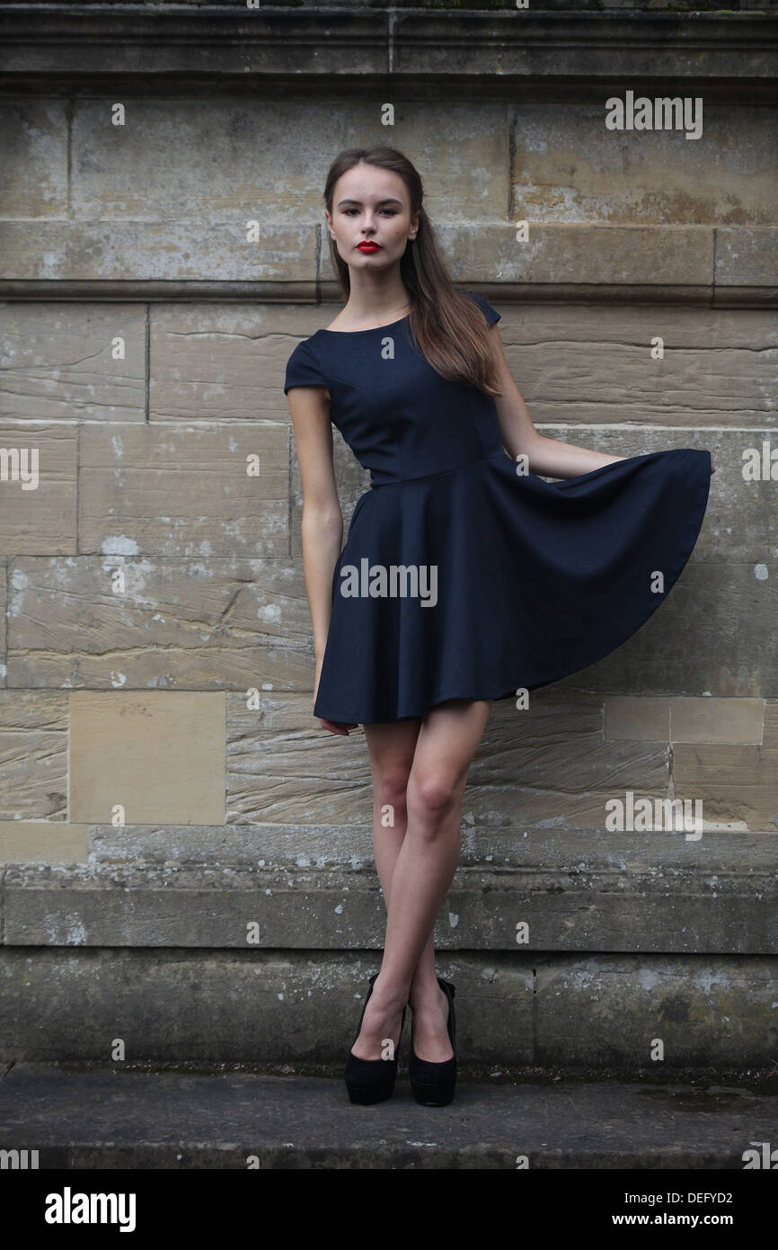 Schöne Mädchen Blick direkt auf die Kamera Ganzkörper erschossen Holding Kleid zur Seite Stockfoto