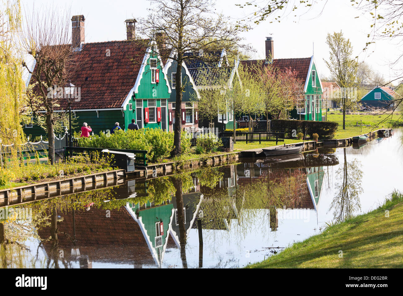 Historische Windmühlen und Häuser in Zaanse Schans an den Ufern des Flusses Zaan, in der Nähe von Amsterdam Zaandam, Niederlande Stockfoto