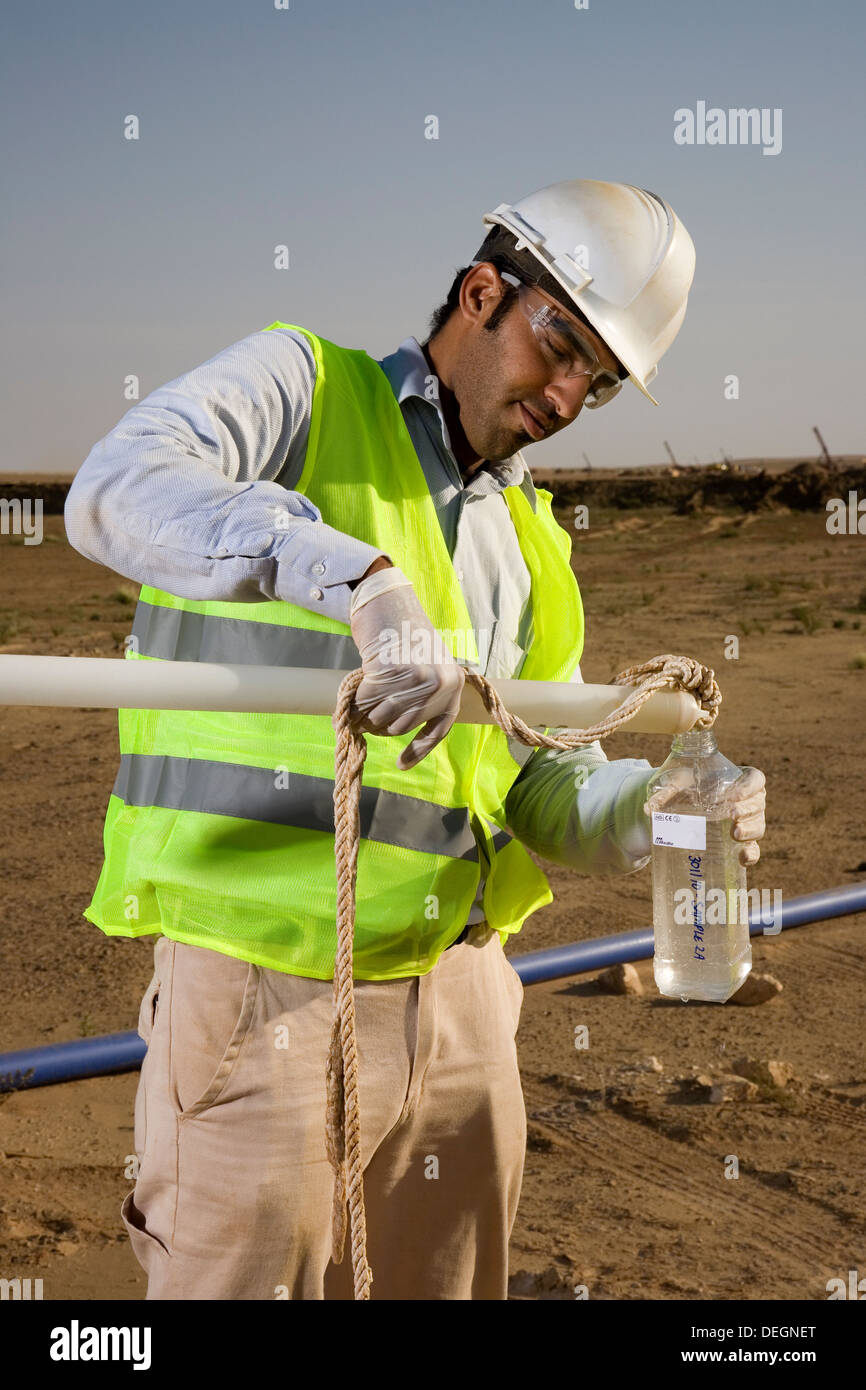 Nehmen Wasser, die Proben aus trug Loch, um zu testen, Qualität auf industriellen Goldabbau Komplex, Mauretanien, NW-Afrika Stockfoto