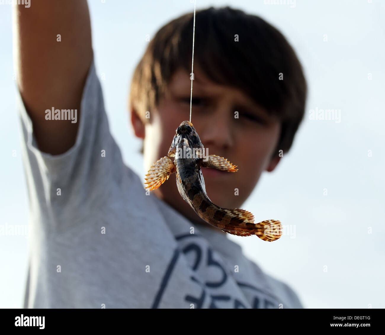 Junge mit wenig Fisch gefangen am Haken Stockfoto