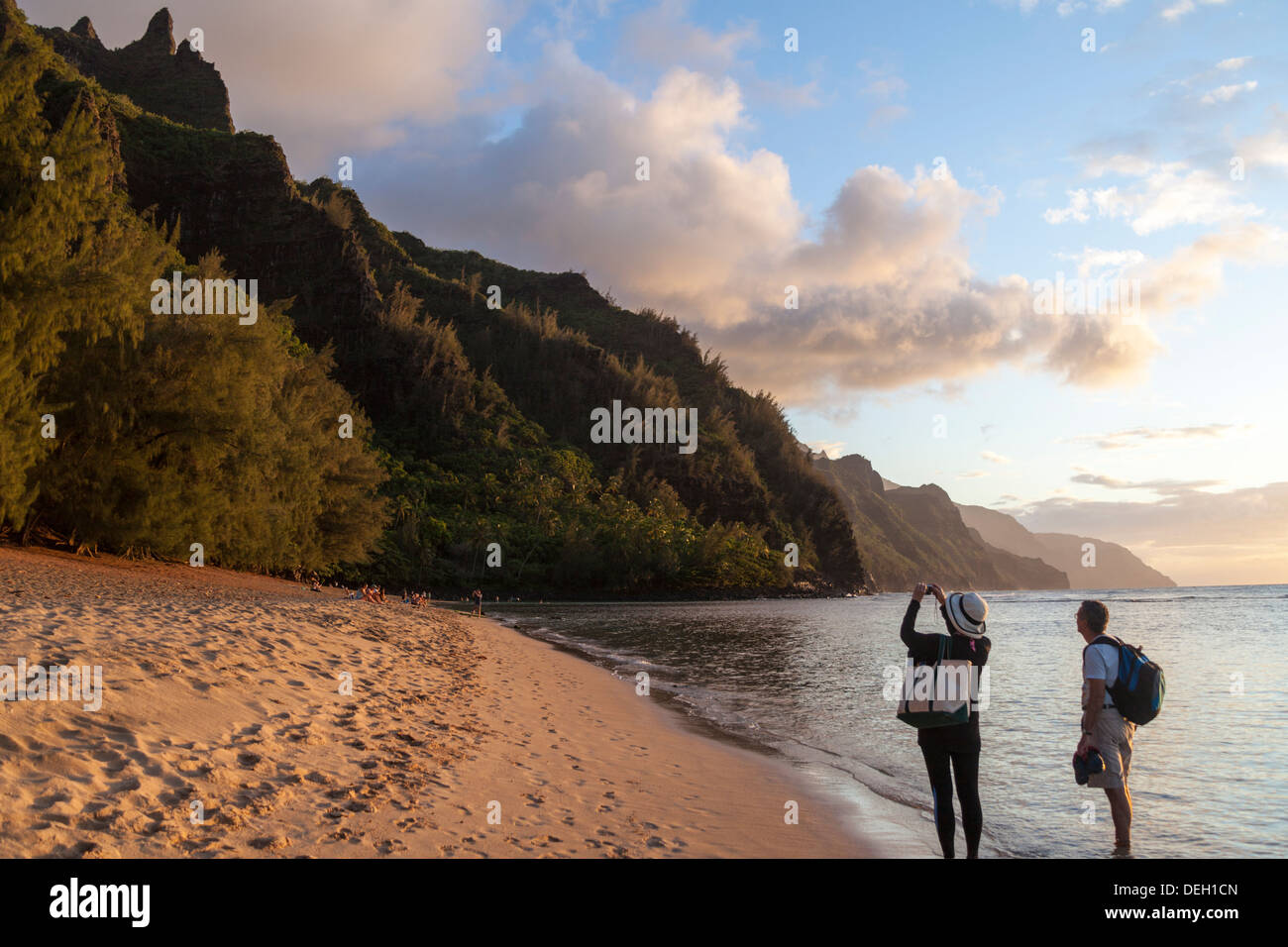 Tourist nimmt Foto Kee Beach bei Sonnenuntergang, wenn golden die Na Pali Coast leuchtet Stockfoto