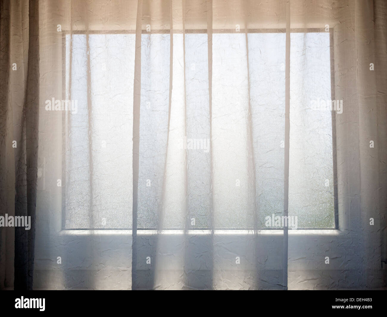 transparenter Vorhang mit kleinen Fenster hinter Stockfoto