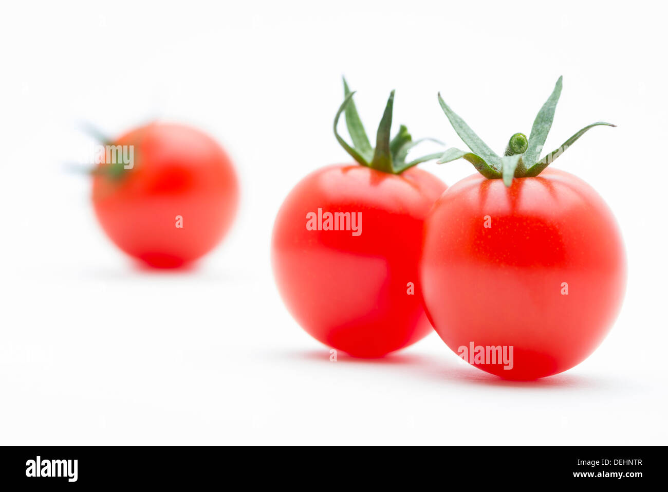 Ein Makro Nahaufnahme von drei saftigen frische und schmackhafte Kirschtomaten in Folge Stockfoto