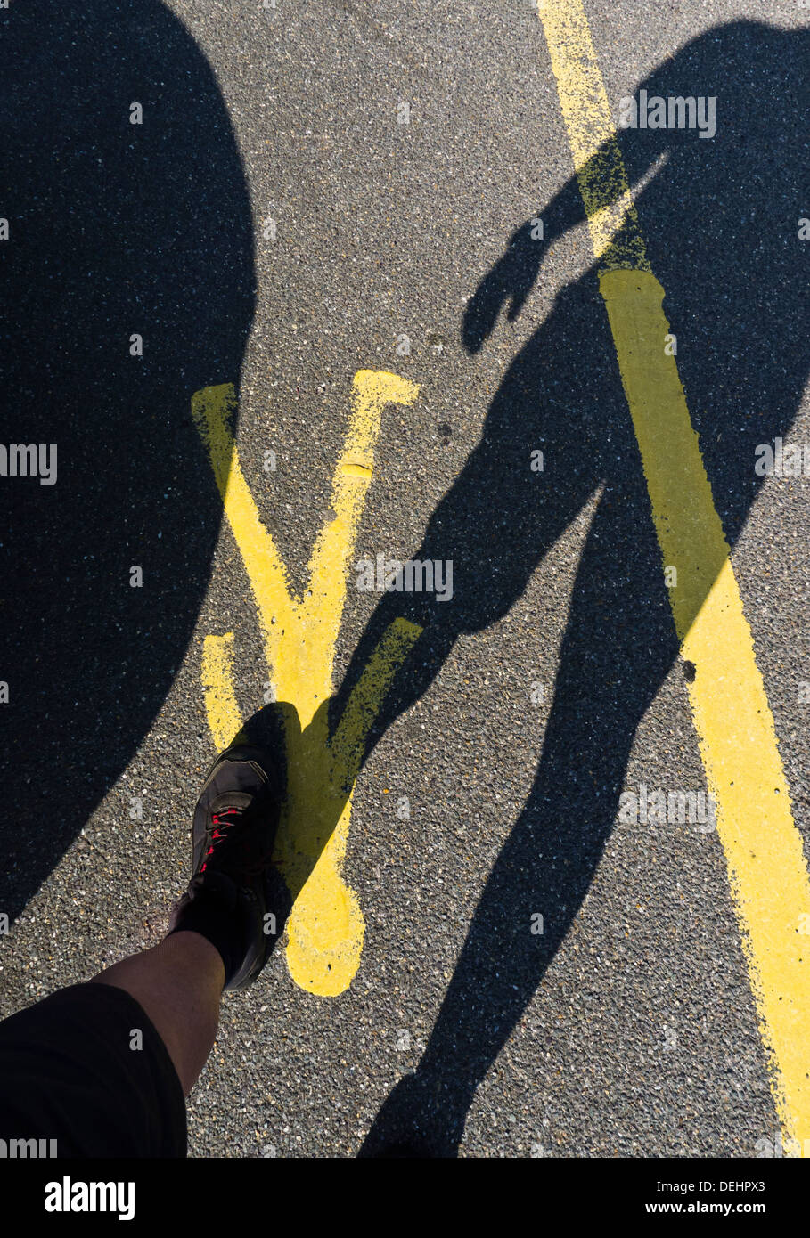 Schatten ein Mann zu Fuß in einer Fußgängerzone befindet. Stockfoto