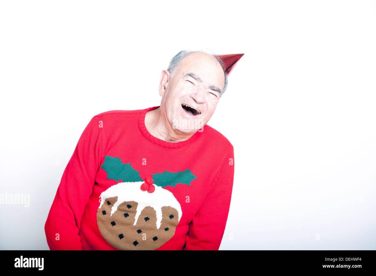 Senior erwachsenen Mann trägt einen Weihnachtspullover ein roter Partyhut Stockfoto