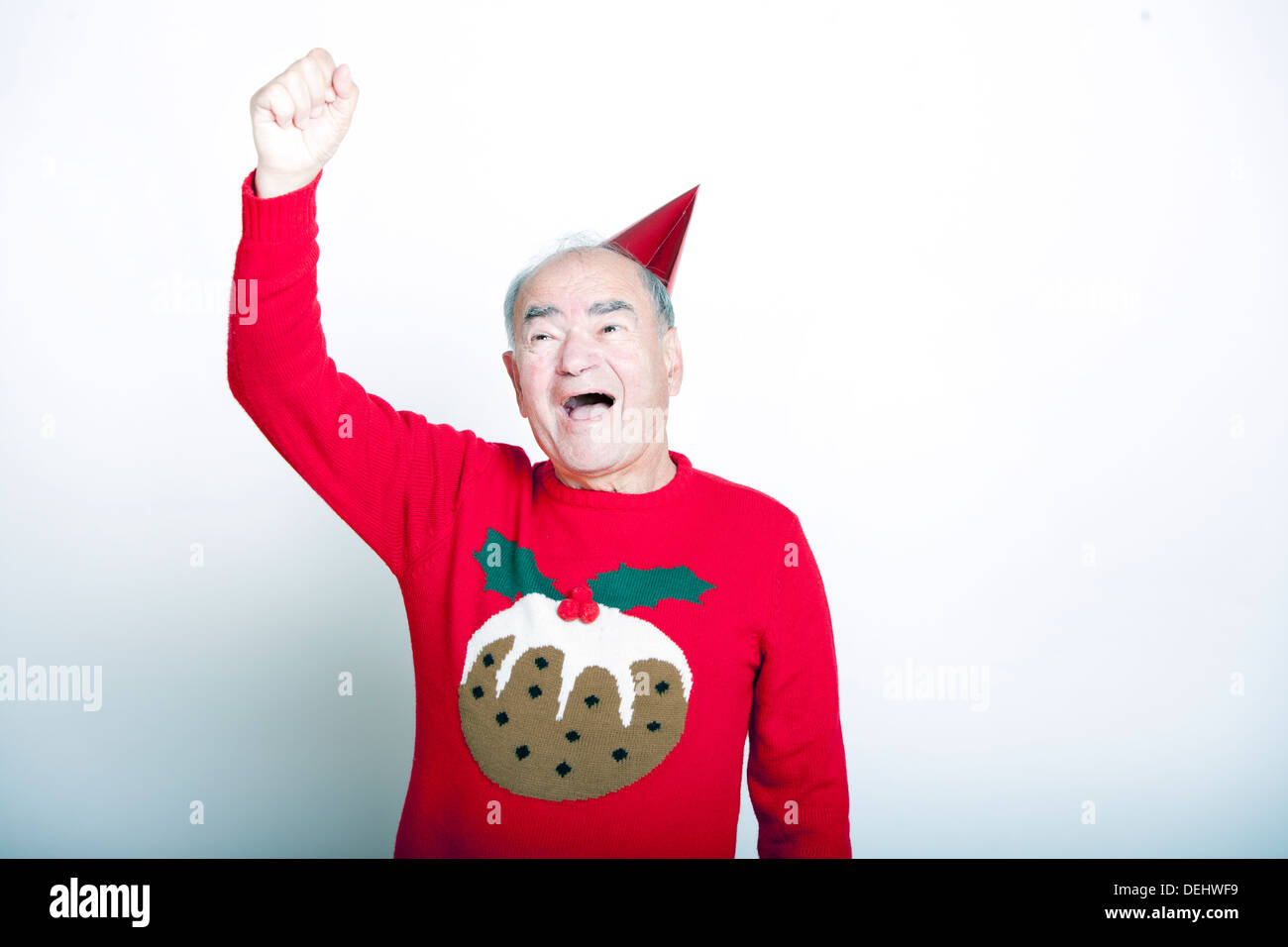 Älteren Erwachsenen Mannes tragen Weihnachtspullover seinen Arm in die Luft heben Stockfoto