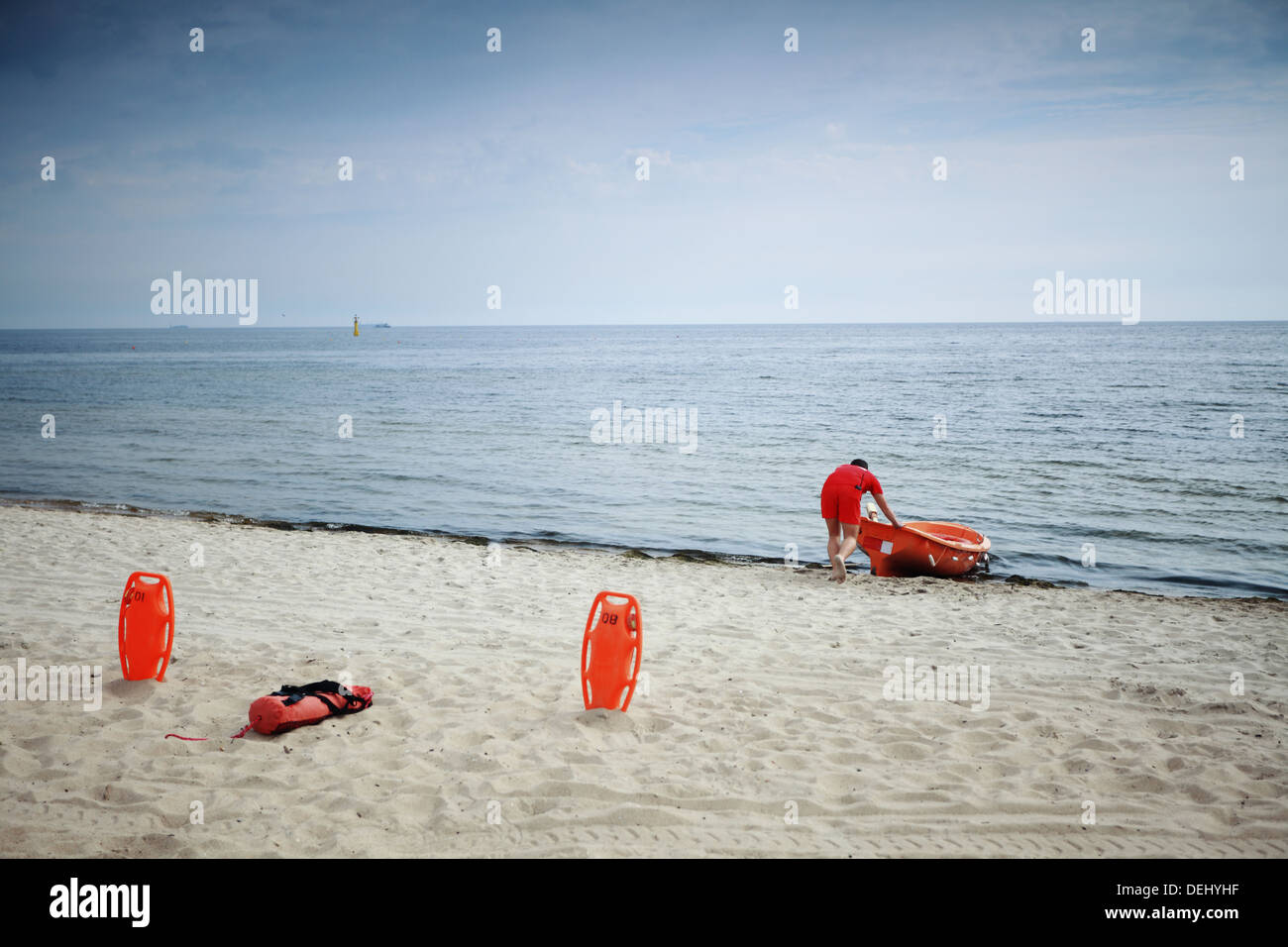 Am Strand Leben retten. Rettungsschwimmer Rettungsgerät Ausrüstung orange Bewahrer und Boot, roten Kunststoff Schwimmhilfe im sand Stockfoto