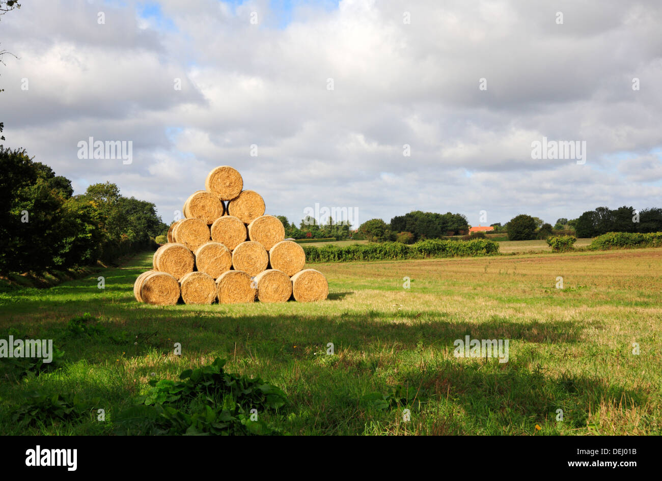 Eine Landschaft-Szene nach der Ernte mit Stroh Stack auf einem Bauernhof in North Norfolk. Stockfoto