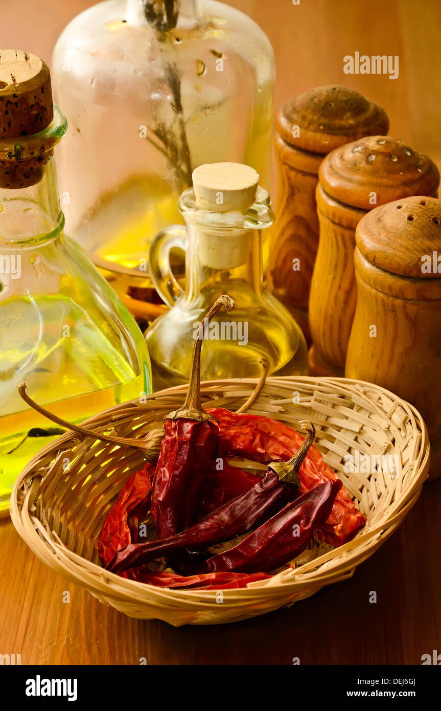 Korb mit getrockneten Chilischoten, Öl und Gewürze Stockfoto