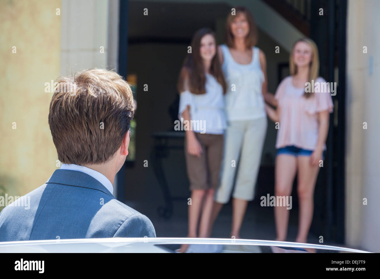 Ein Vater & Ehemann nach Hause von der Arbeit zu sehen, seine Familie Frau und zwei Töchter Stockfoto