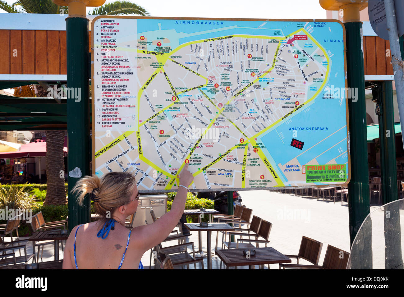 Lady auf der Suche im Lageplan der Straßen und Gassen von Lefkas Stadt Lefkada Griechisch Insel Griechenland zeigt die Wahl Zeichen Stockfoto