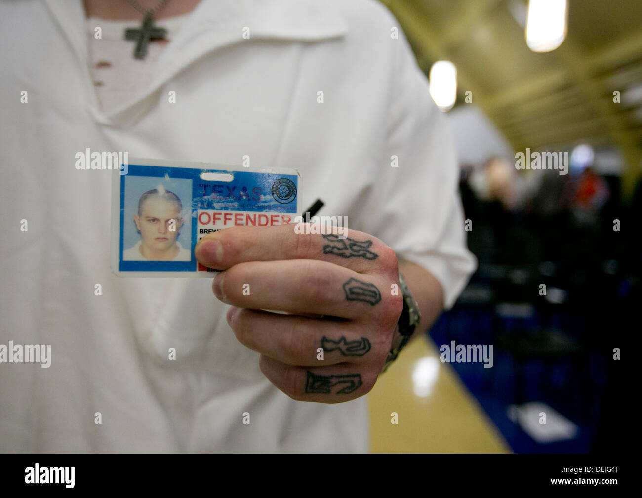 Eine weiße männliche Gefangene mit verschiedenen Tattoo auf der Hand, hält seine Identifikationskarte Texas Täter Stockfoto