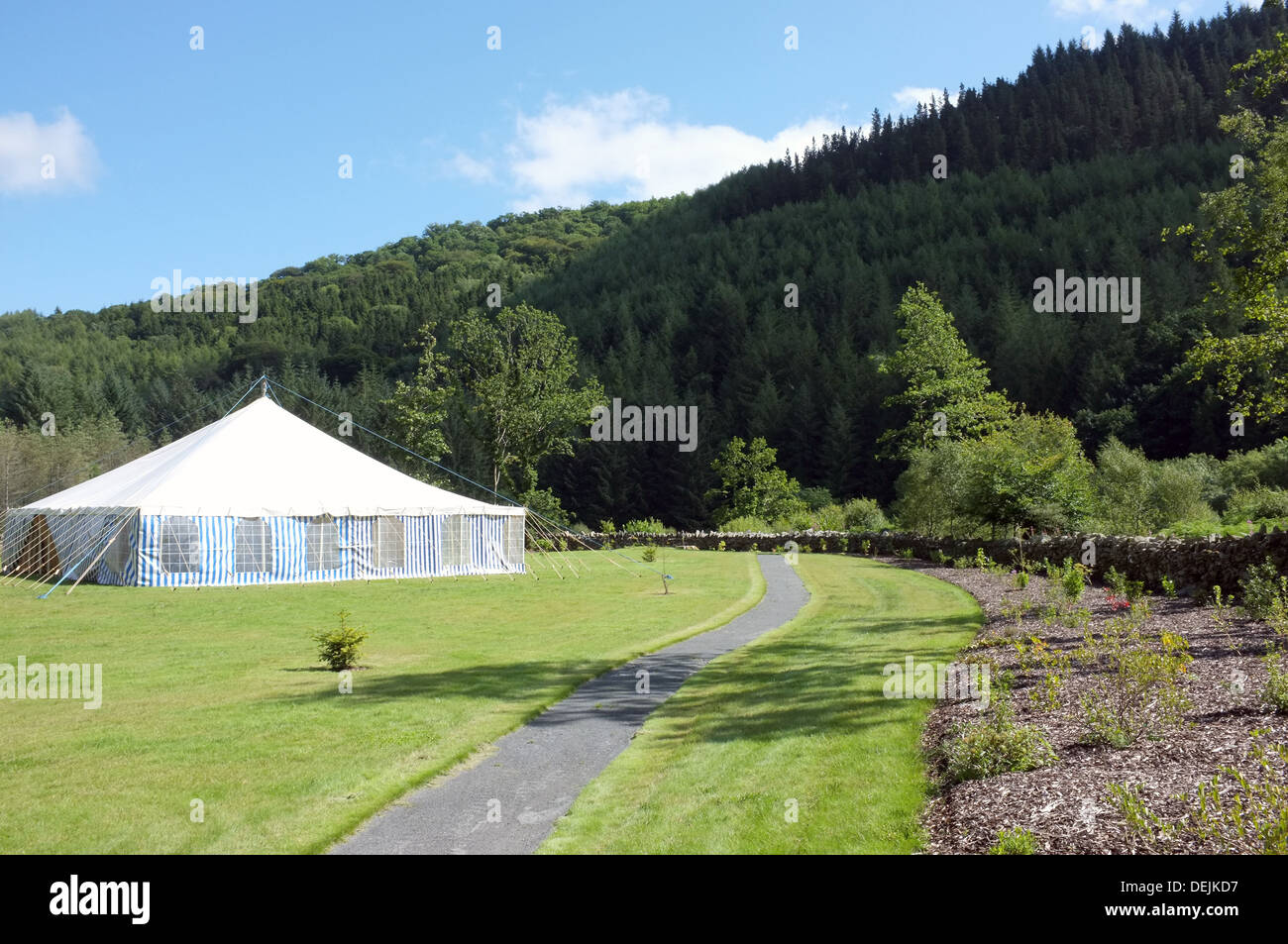 Ein weißes Festzelt vor der Kulisse der Baum besetzt walisische Hügeln. Stockfoto