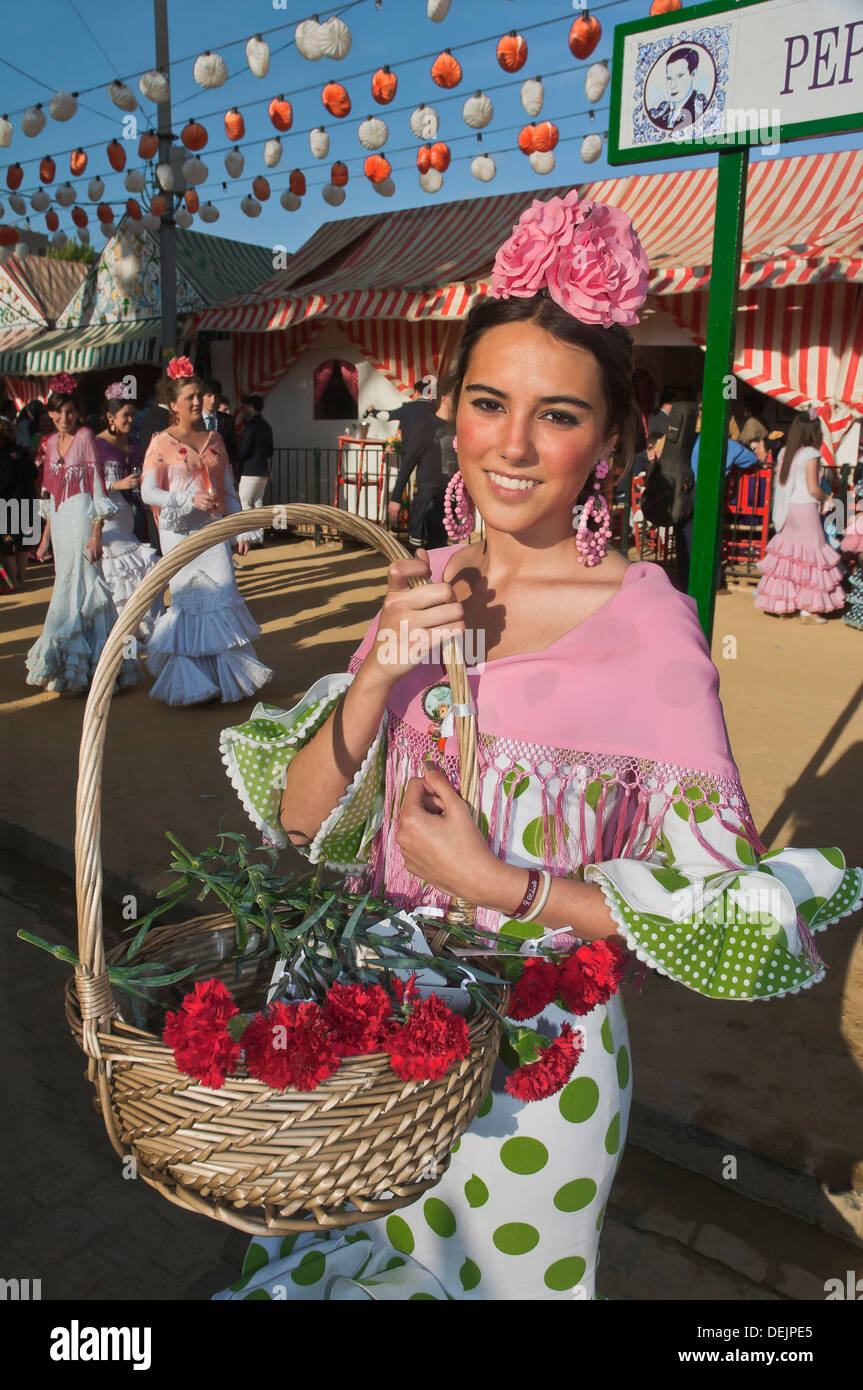 April Messe, junge Frau trägt ein traditioneller Flamenco Kleid und mit Blumenkorb, Sevilla, Andalusien, Spanien, Europa Stockfoto