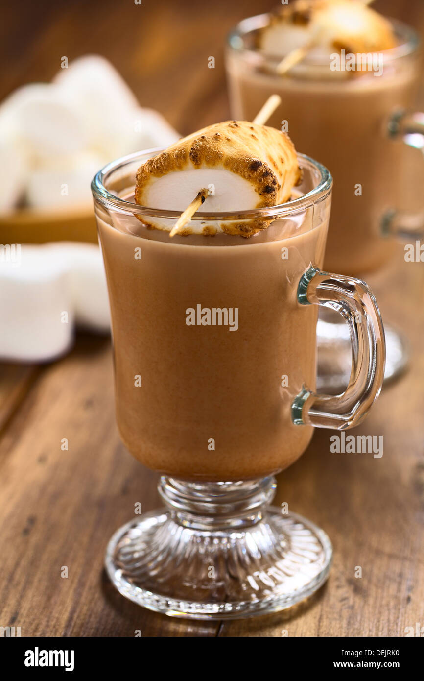 Heiße Schokolade mit gerösteten Marshmallow am Spieß auf dunklem Holz Stockfoto