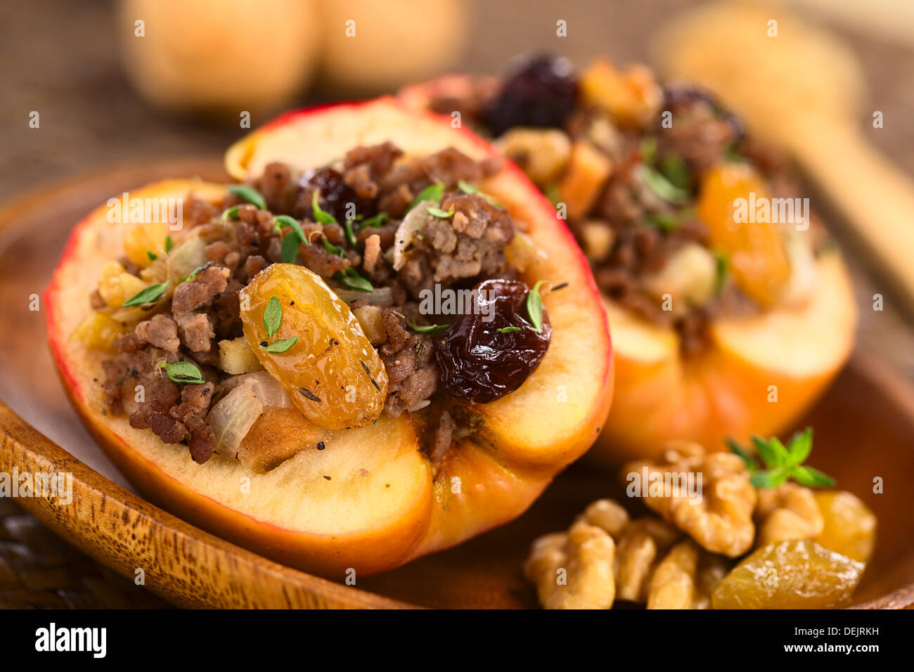 Bohnenkraut gebackene Apfel gefüllt mit Hackfleisch, Rosinen, Sultaninen, Zwiebel und Walnuss, bestreut mit frischer Thymian obenauf Stockfoto