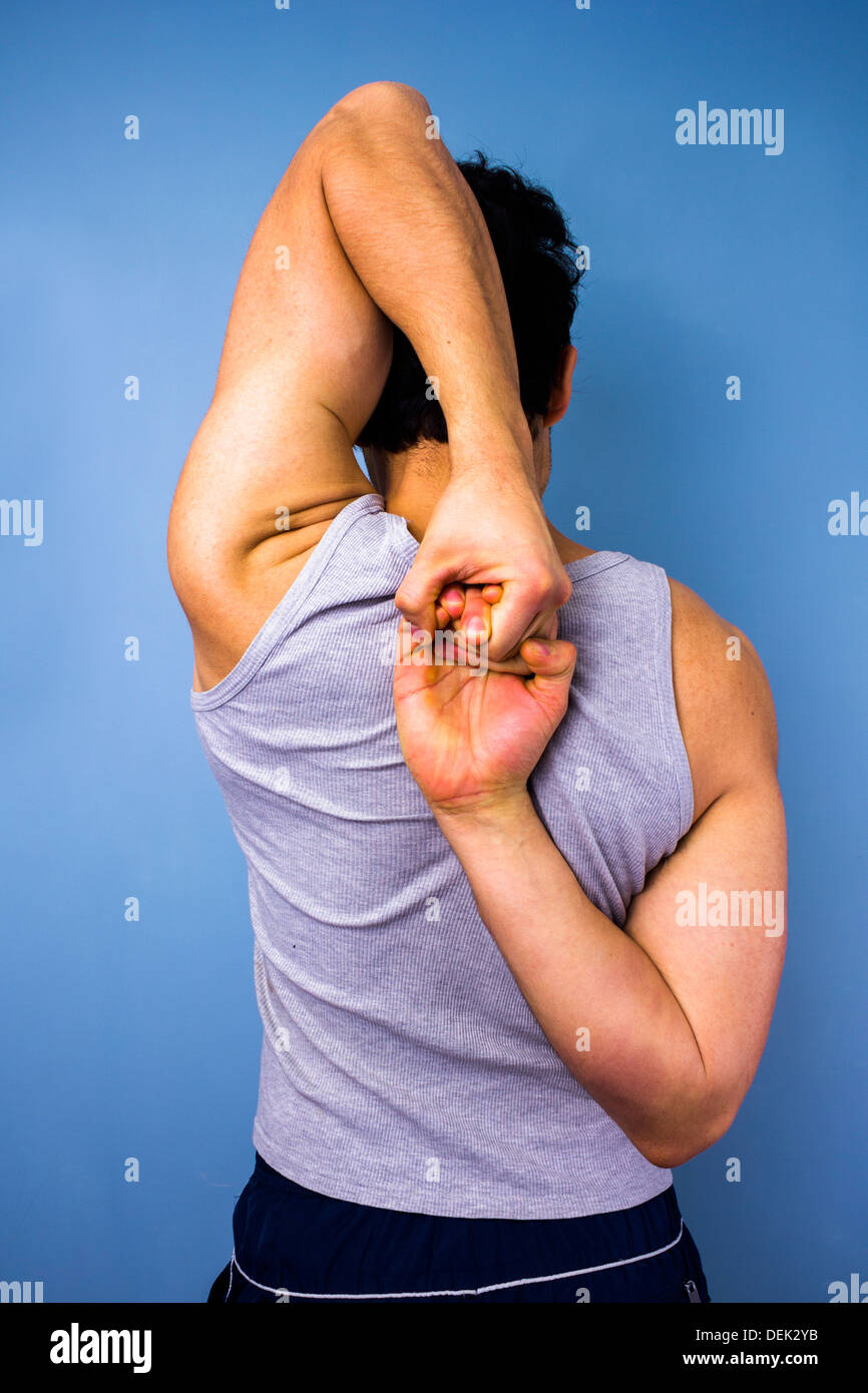 Rückansicht des jungen Mann streckte seine Arme hinter seinem Rücken Stockfoto