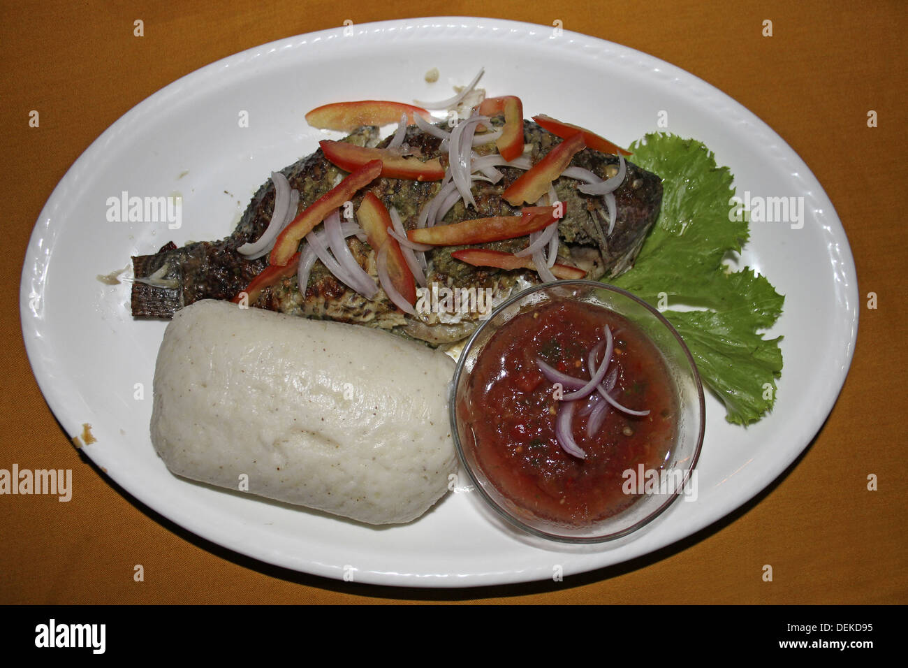 Typische ghanaische Essen von Tilapia und Banku (gegorener Mais/Maniok Teig) mit würzigen Chili-Sauce Stockfoto