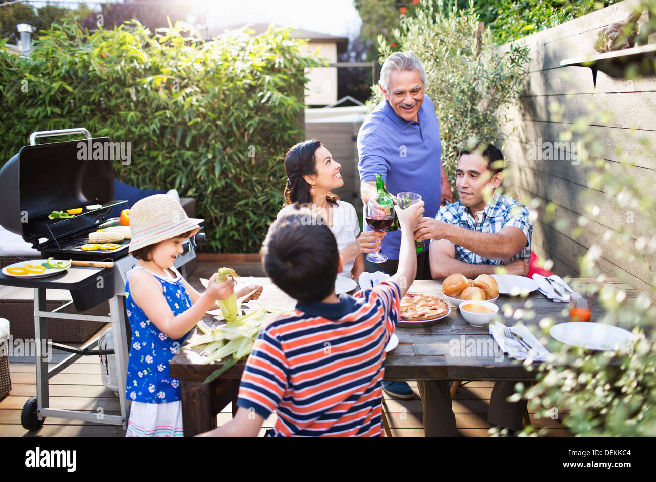 Familie Toasten miteinander am Tisch im freien Stockfoto