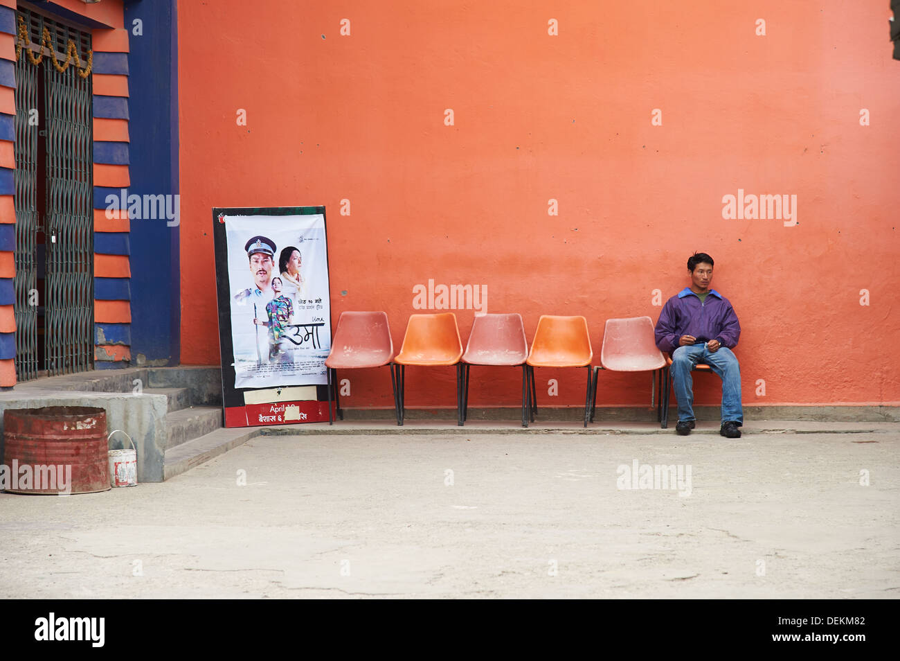 Ein Mann sitzt allein vor einem nepalesischen Kino warten offenbar auf die Vorführung eines Films, Kathmandu Stockfoto