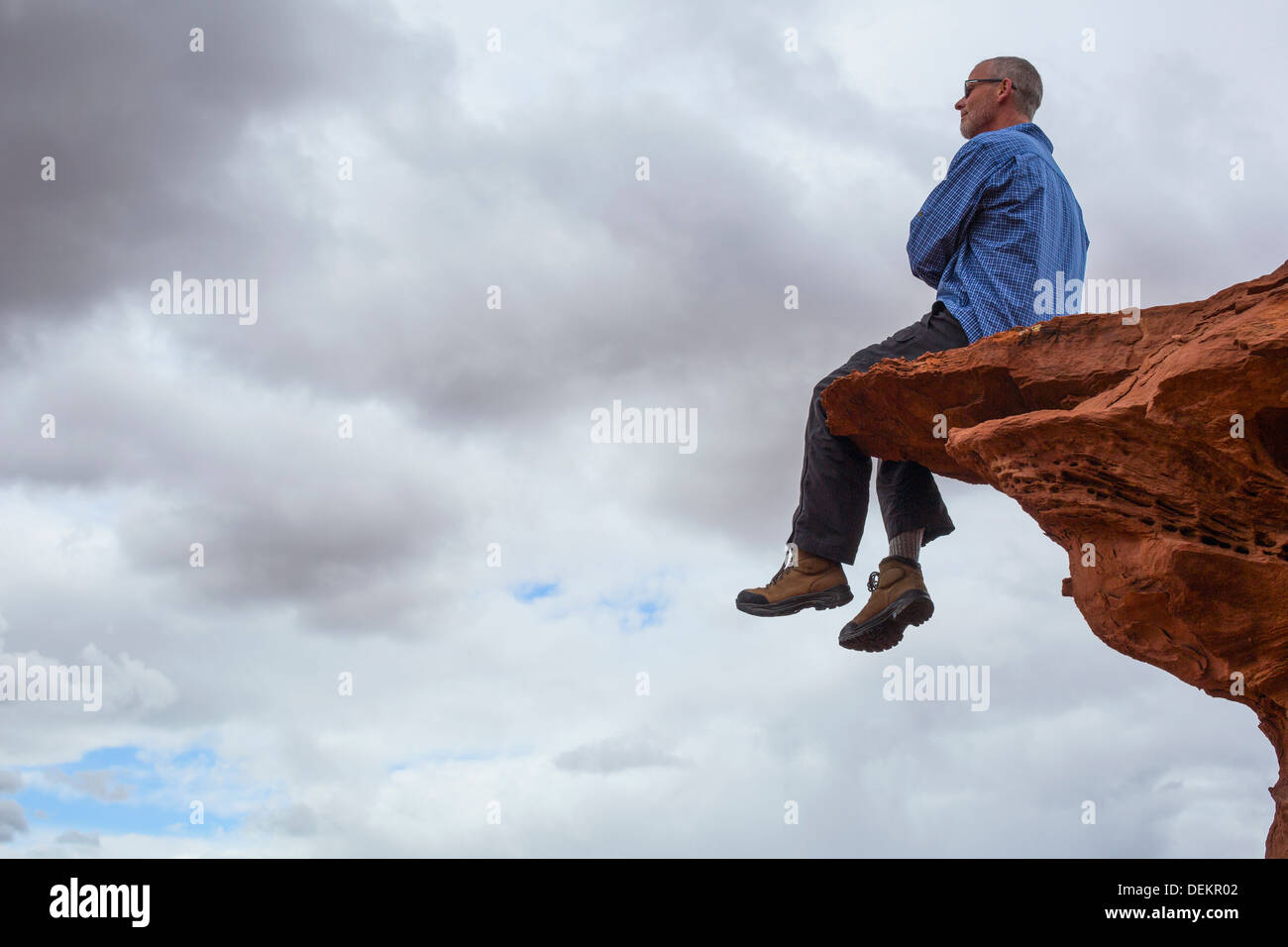 Kaukasischen Mann sitzt auf der Klippe Stockfoto