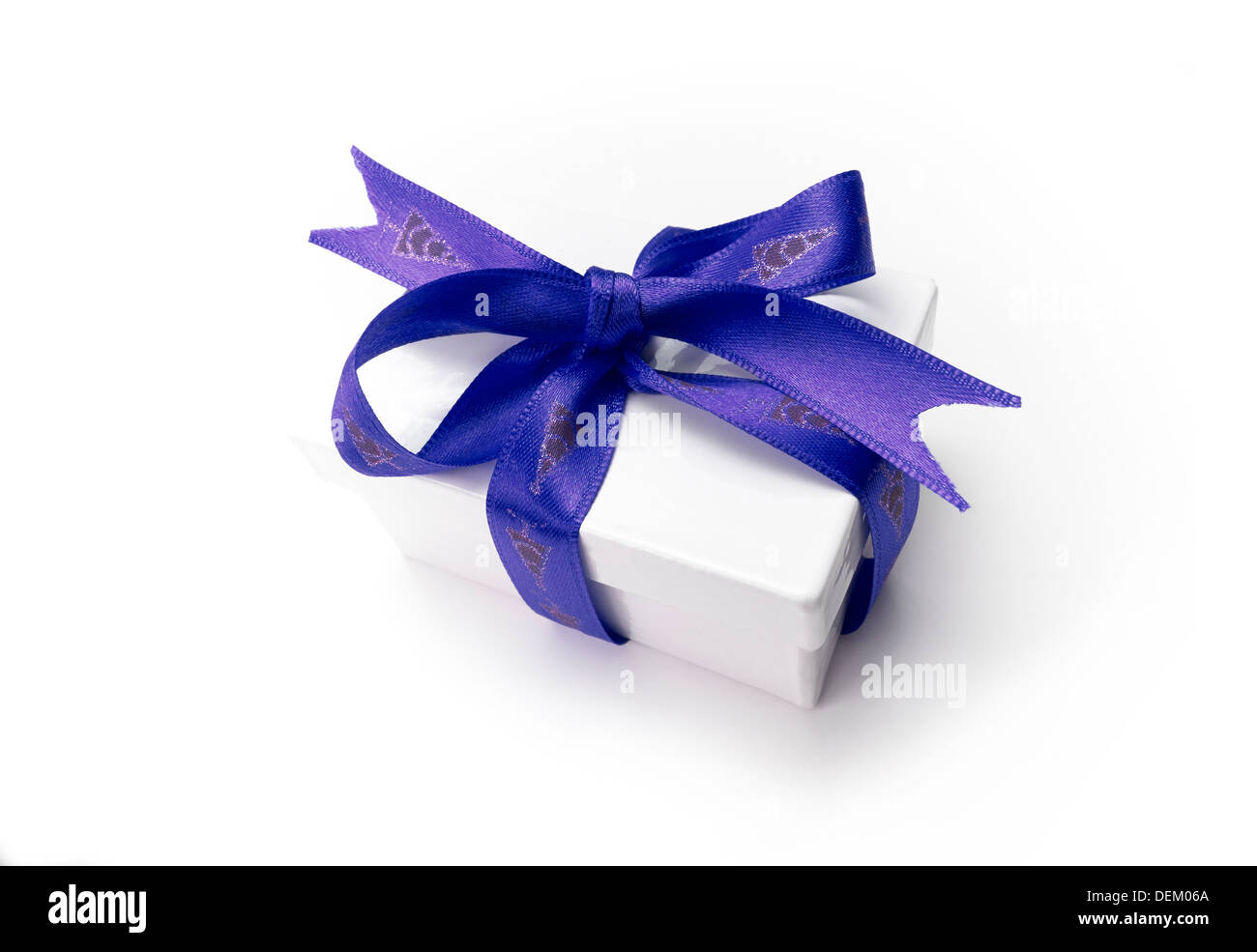 Verpackte Weihnachtsgeschenk mit einem bunten blaues Band und Bogen auf einem weißen Hintergrund. Stockfoto