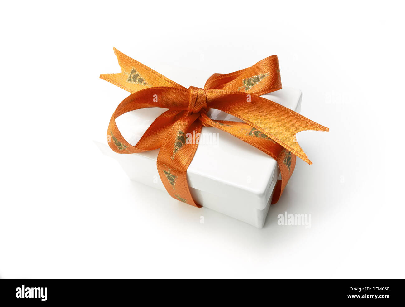 Verpackte Weihnachtsgeschenk mit einem bunten Goldband und Bogen auf einem weißen Hintergrund. Stockfoto