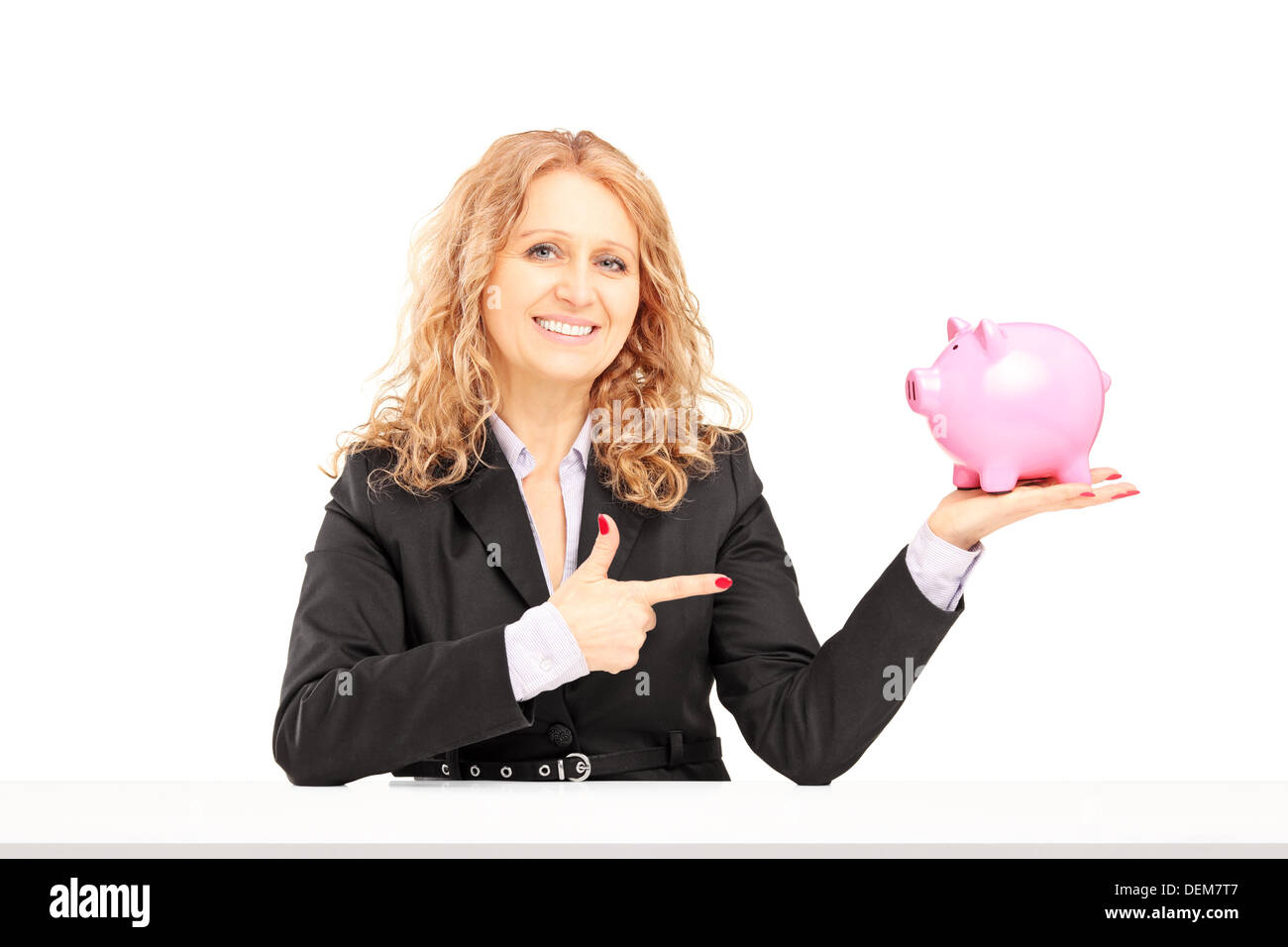 Reife Frauen halten ein Sparschwein und deutete lächelnd Stockfoto