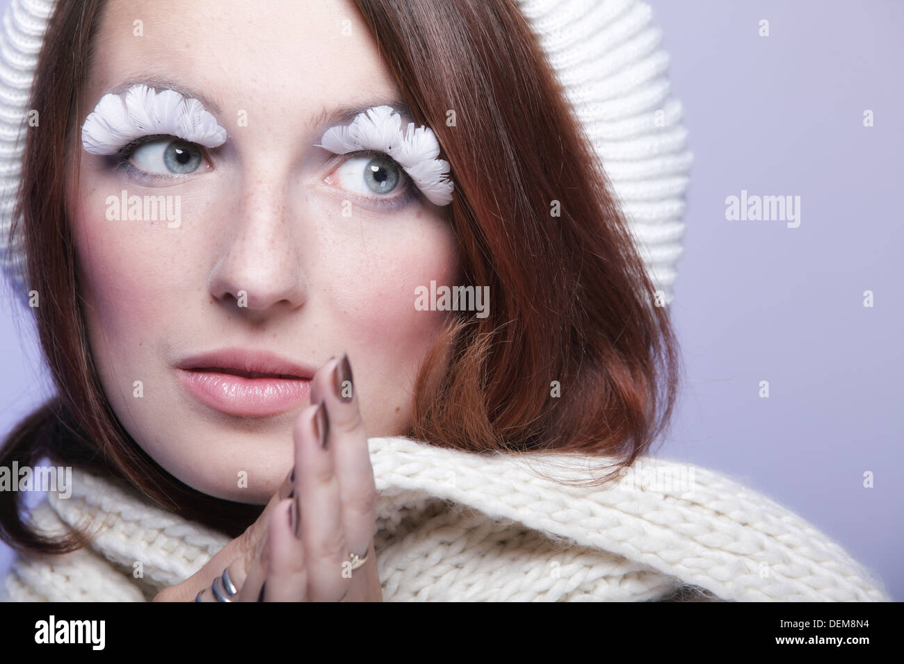 Winter-Mode, die schöne Frau in warme Kleidung stilvoll kreativ machen falsche langen weißen Auge Wimpern blauen Hintergrund Stockfoto