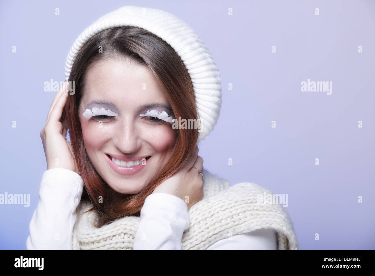 Winter-Mode, die schöne Frau in warme Kleidung stilvoll kreativ machen falsche langen weißen Auge Wimpern blauen Hintergrund Stockfoto