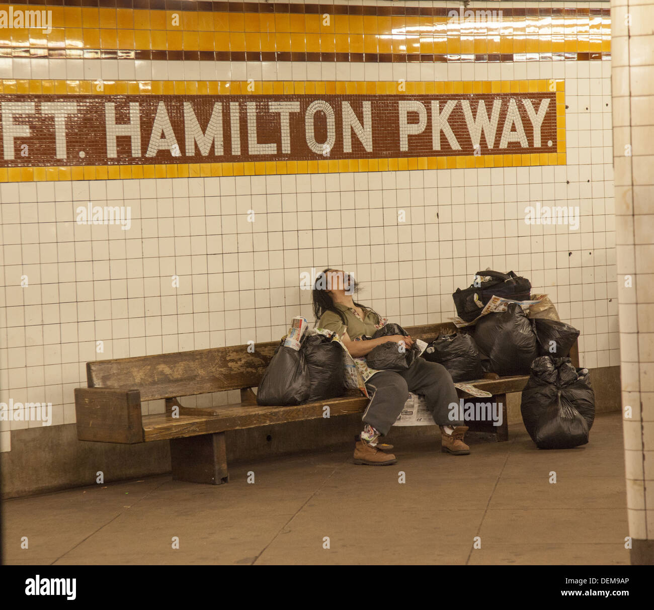 Obdachloser mit seinen Besitz auf der Plattform an einer u-Bahnstation in Brooklyn, New York. Stockfoto
