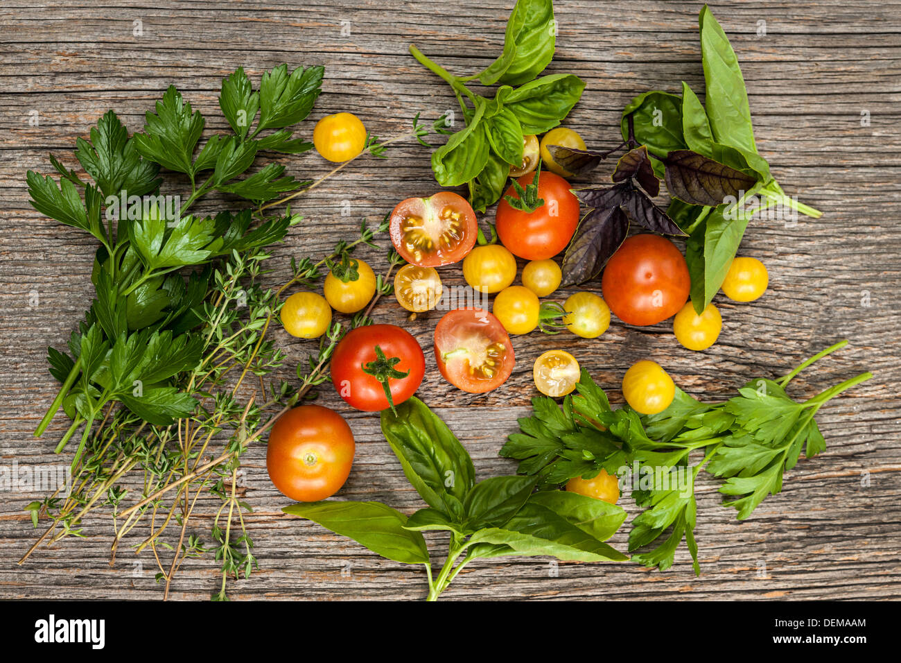 Frischen bunten Tomaten und Kräutern auf rustikalen hölzernen Hintergrund von oben Stockfoto