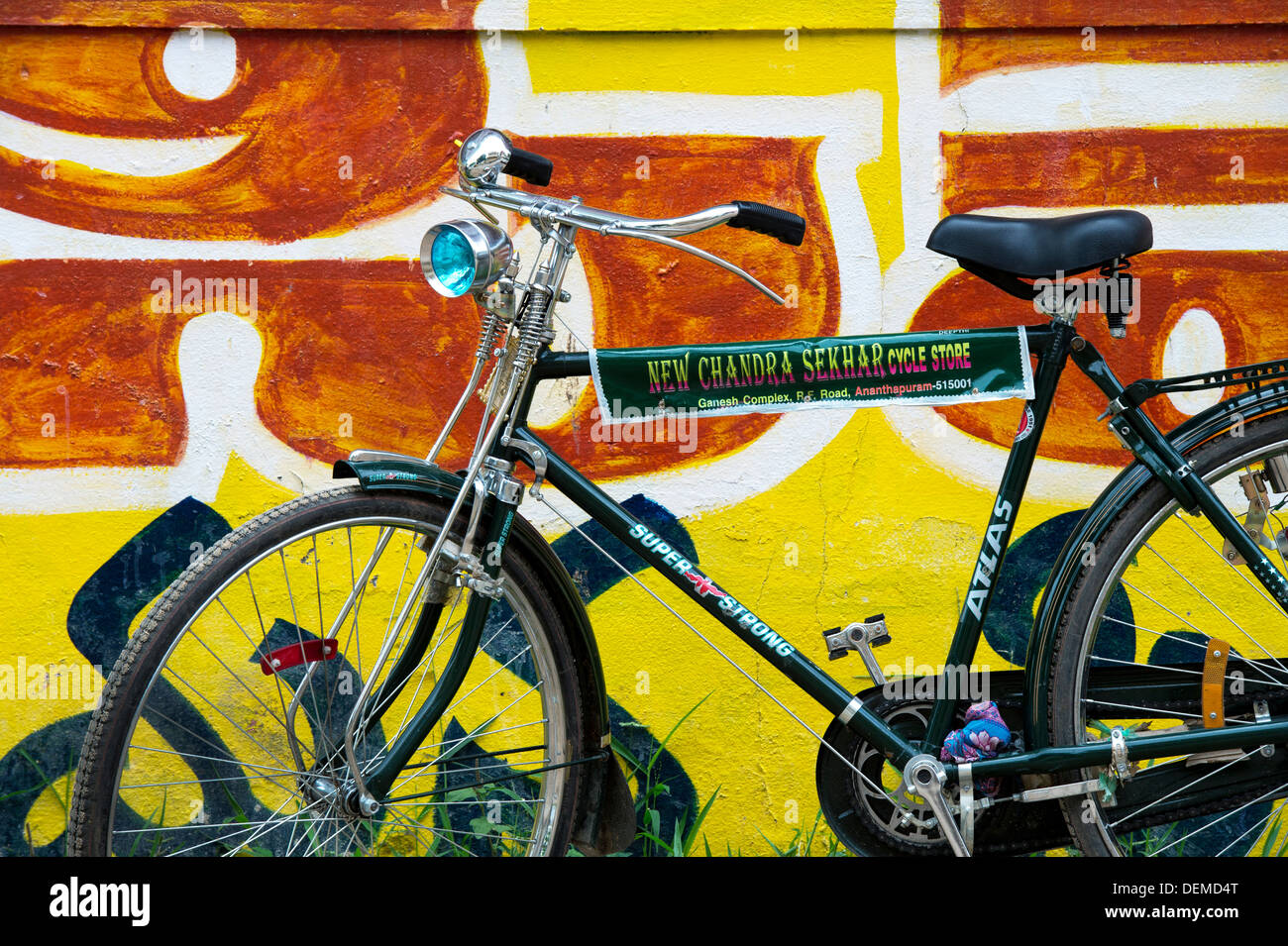 Traditionelle indische Fahrrad gegen eine gemalte gelbe indische Wand. Andhra Pradesh, Indien Stockfoto