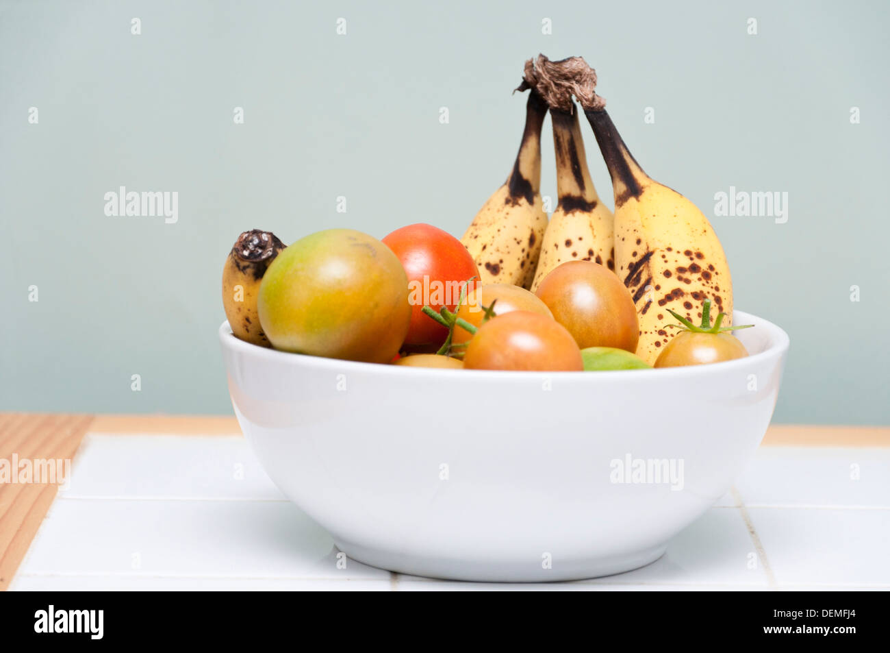 Reife Tomaten im Innenbereich mit Ethylen-Gas aus reifen Bananen helfen. Stockfoto