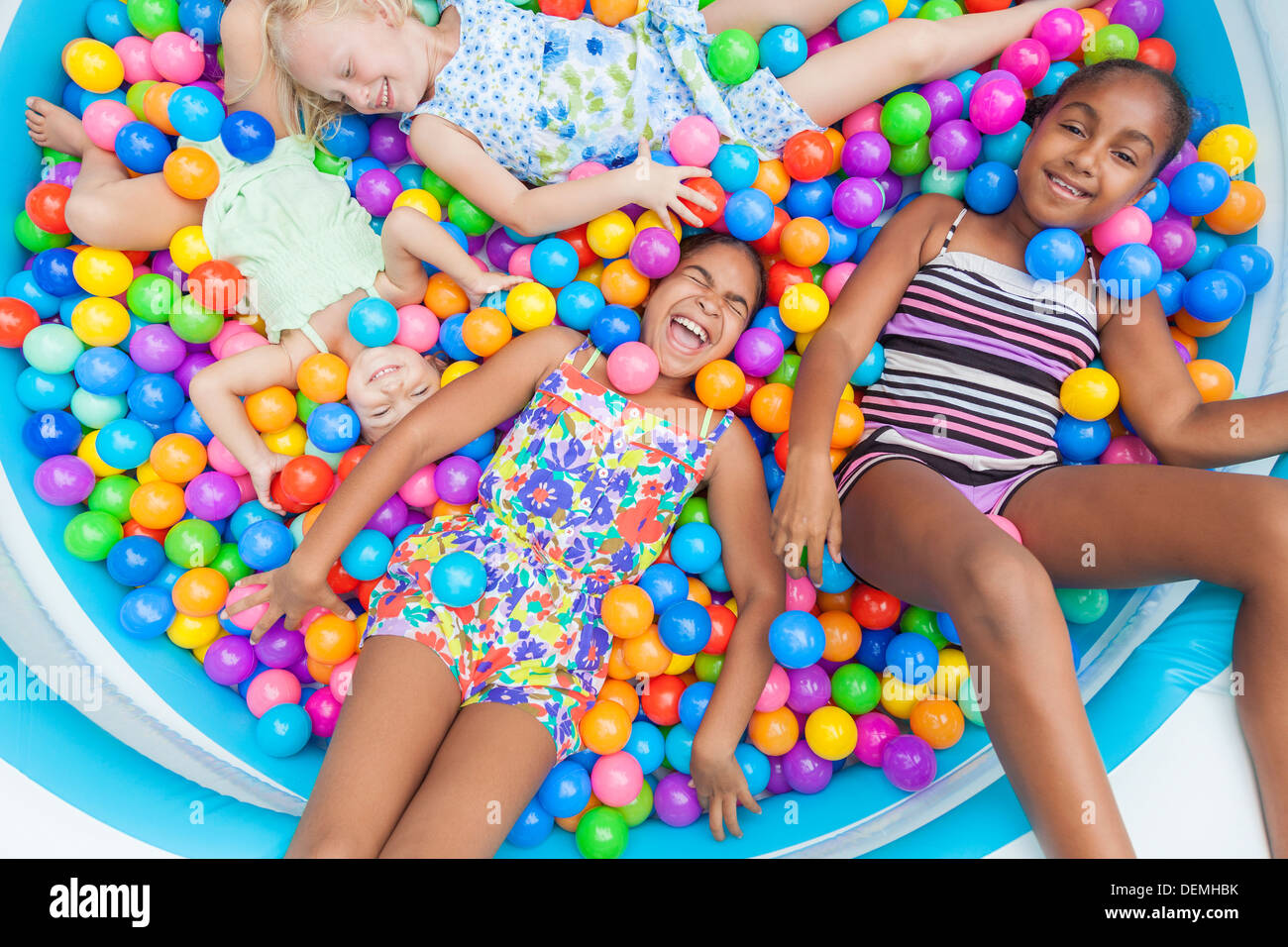 Interracial-Gruppe von Mädchen, blond und African American Kinder Spaß Lachen, bunten Plastikbällen in ein Bällebad spielen Stockfoto