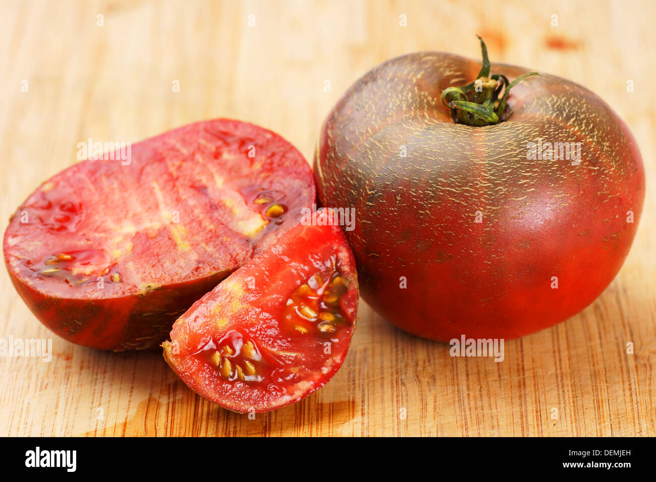 Köstliche schwarze Tomaten auf Bambus Schneidbrett Stockfoto