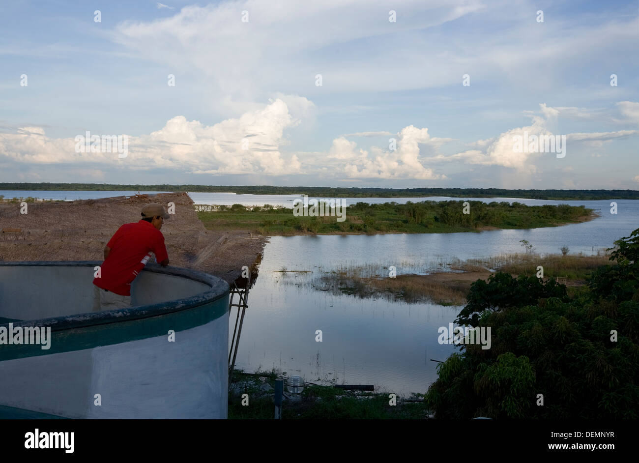 Ein Mann schaut den Amazonas von der Mole von der Stadt Iquitos. Stockfoto