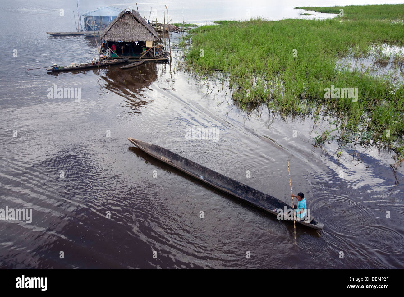 Ein Mann in seiner Hütte am Fluss Ucayali, einem Nebenfluss des Amazonas Richtung rudern Stockfoto