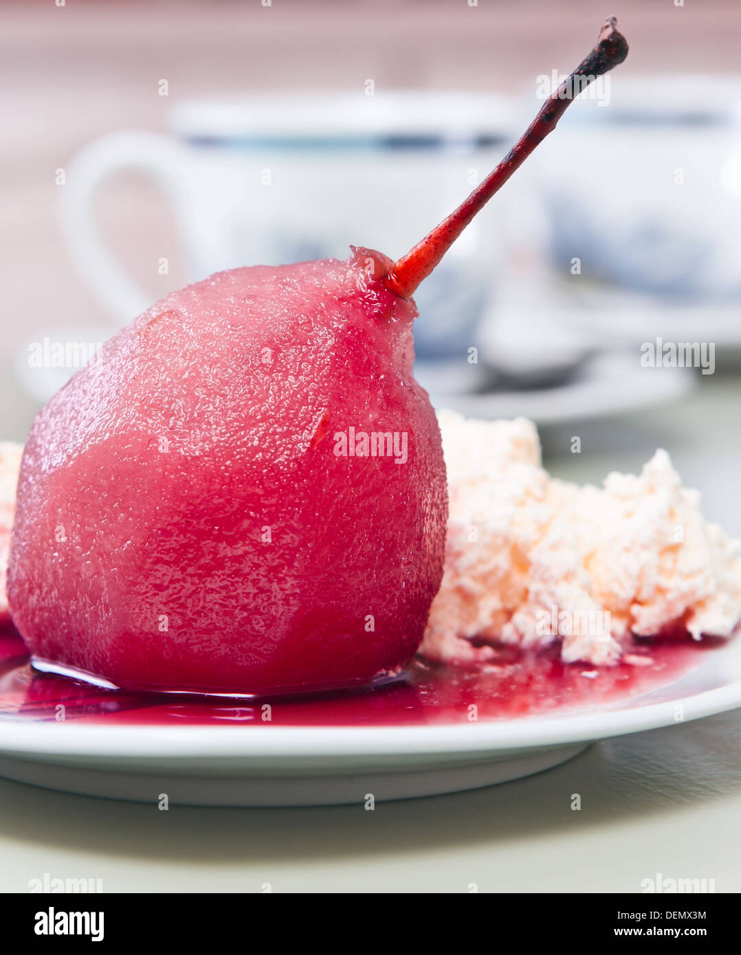 Pochierte Birne und Creme mit Rotweinsauce Stockfoto