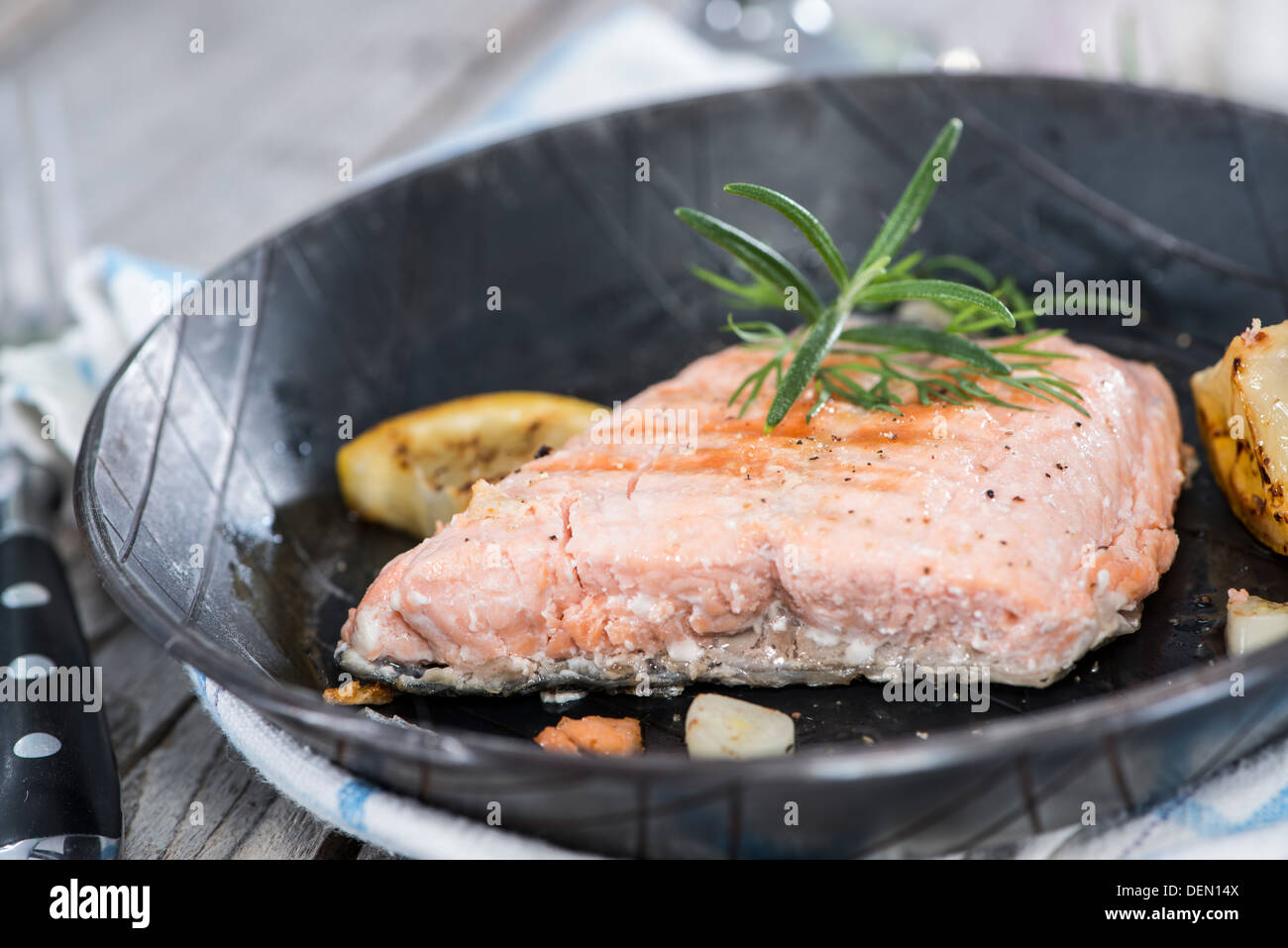 Portion gebratener Lachs in einer Pfanne mit frischen Kräutern Stockfoto