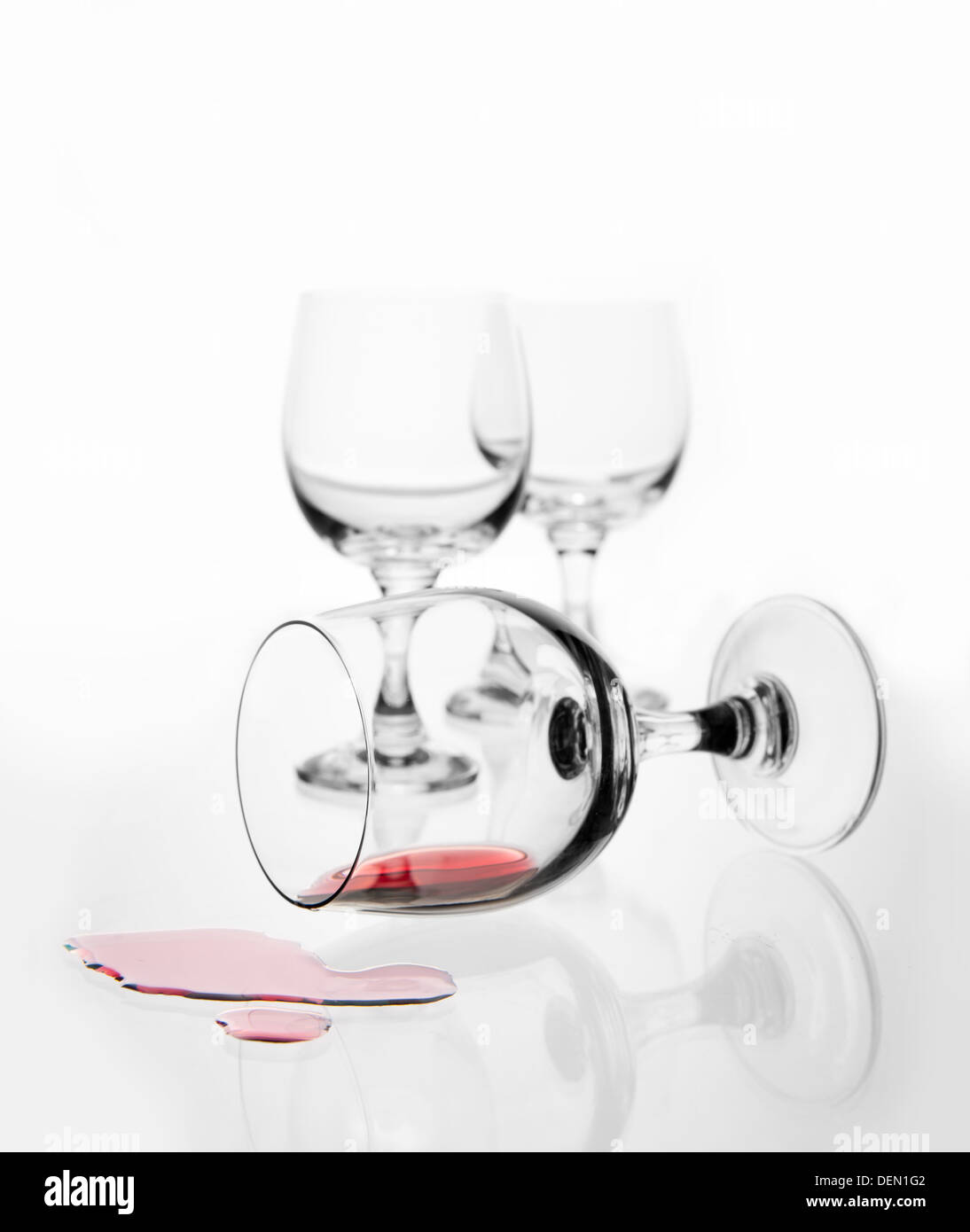 umgestürzten Weinglas mit Rotwein spritzte Stockfoto
