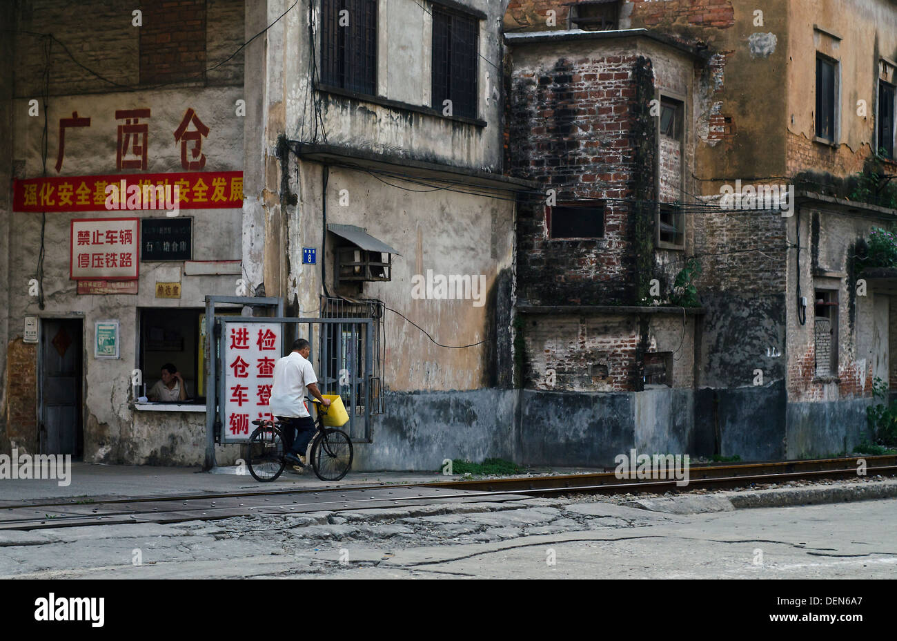 Mann auf dem Fahrrad vor der Fabrik in Guangzhou, China Stockfoto