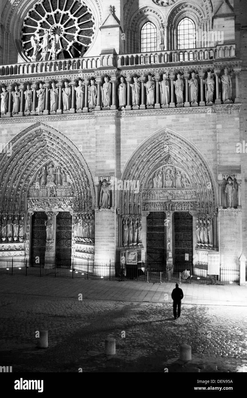 Mann steht außerhalb Kathedrale Notre Dame de Paris (Muttergottes) in der Nacht. Stockfoto