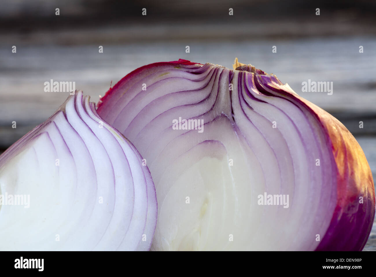 Nahaufnahme des ganzes und eine halbierte frische rote Zwiebel auf einem alten Holztisch Stockfoto